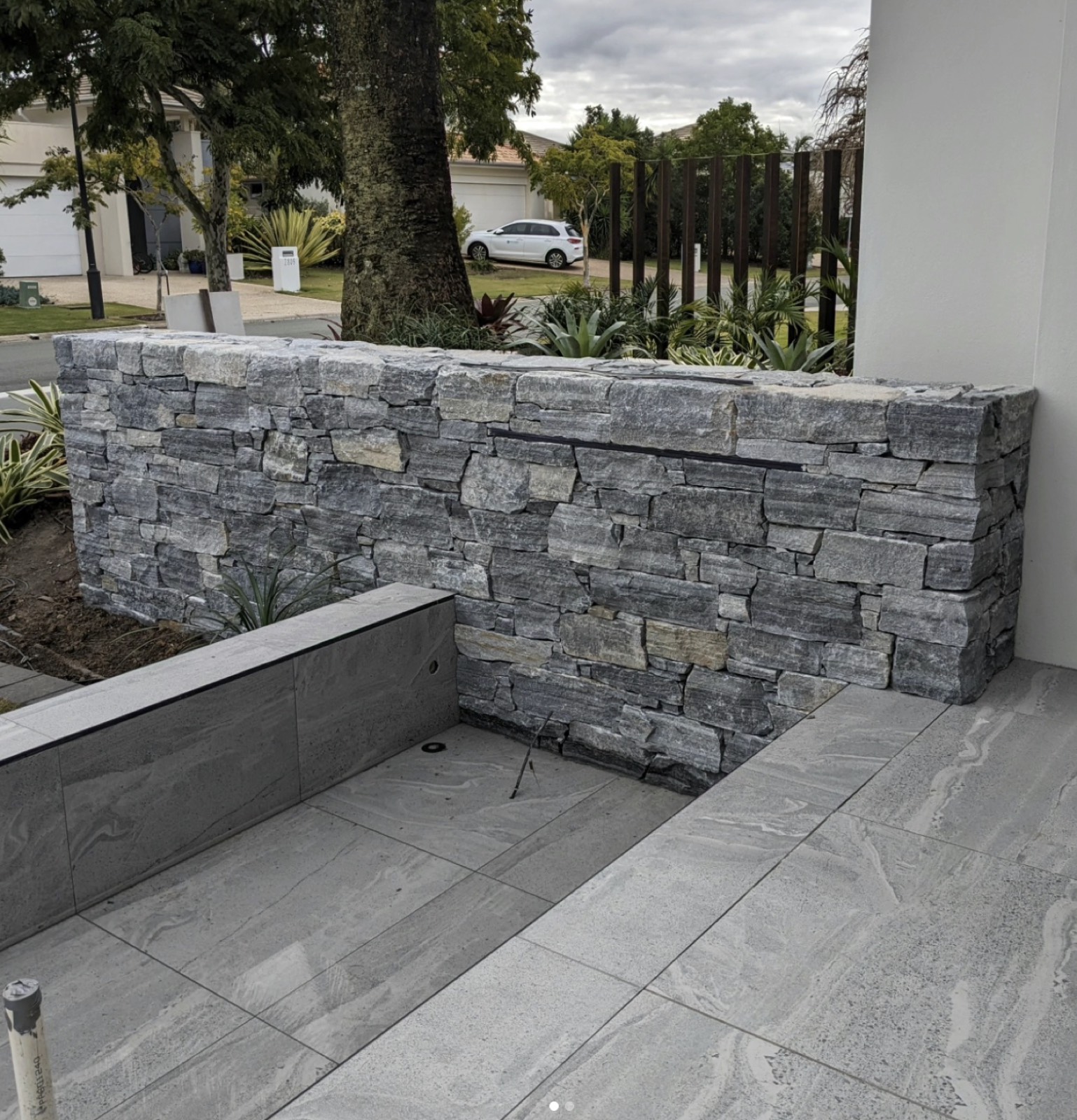 Dry stacked granite feature wall beside a modern entry
